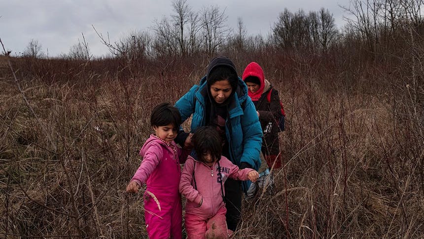 Twee vrouwen lopen met hun twee dochters door bebost gebeid