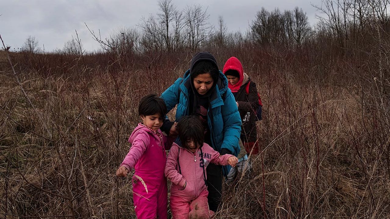 Twee vrouwen lopen met hun twee dochters door bebost gebeid