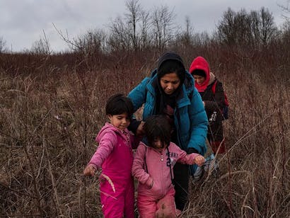 Twee vrouwen lopen met hun twee dochters door bebost gebeid