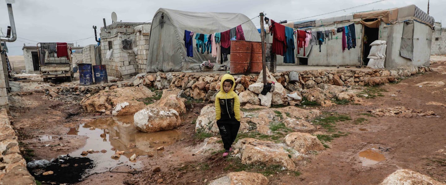 Jongen staat in vluchtelingenkamp in Syrië
