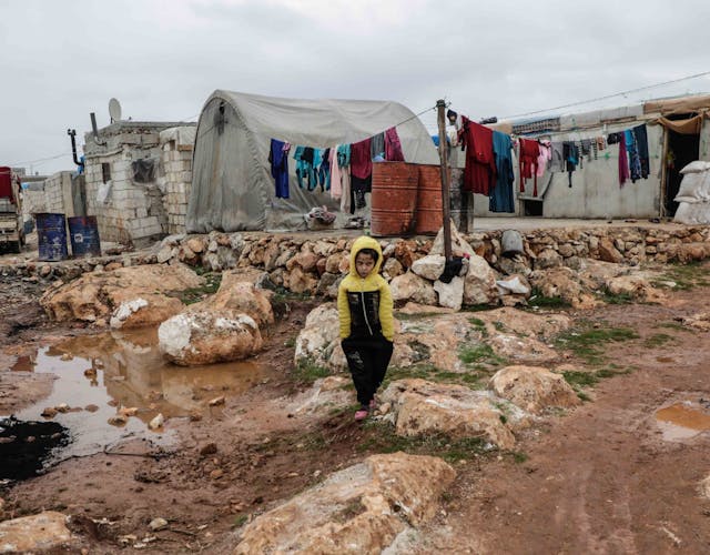 Jongen staat in vluchtelingenkamp in Syrië