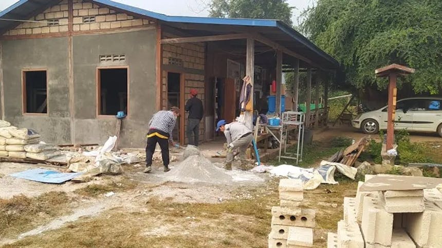 Twee mannen zijn bezig met de bouw van een ziekenhuis