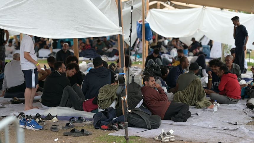 Vluchtelingen zitten in Ter Apel op kleedjes