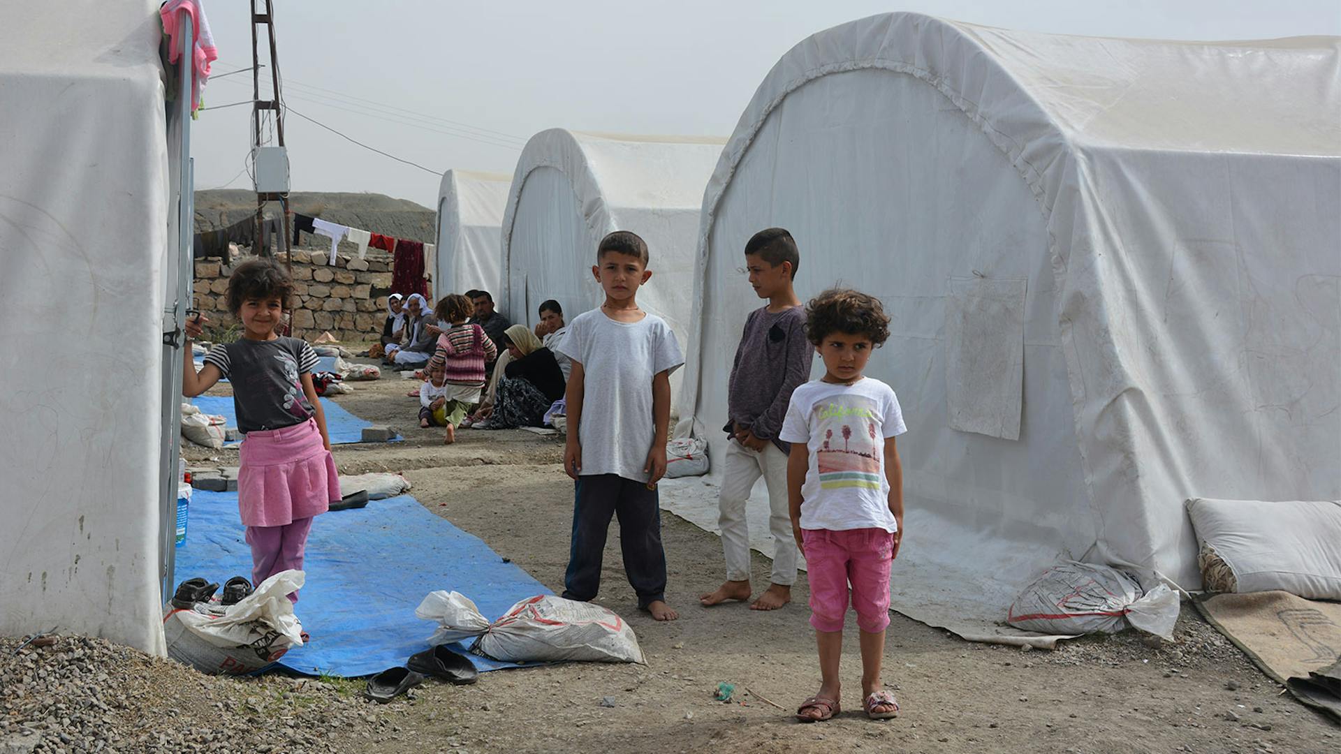 Kinderen staan voor tent in vluchtelingenkamp