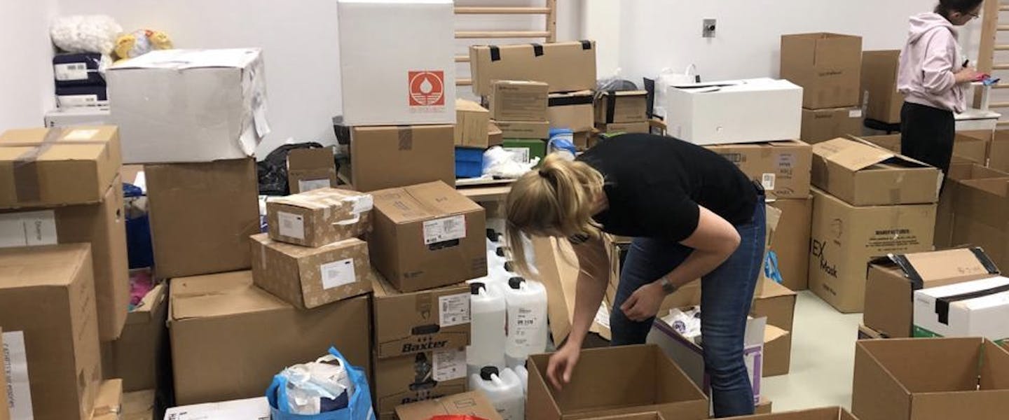 Vrouw graait in doos in pakhuis vol met pakketten