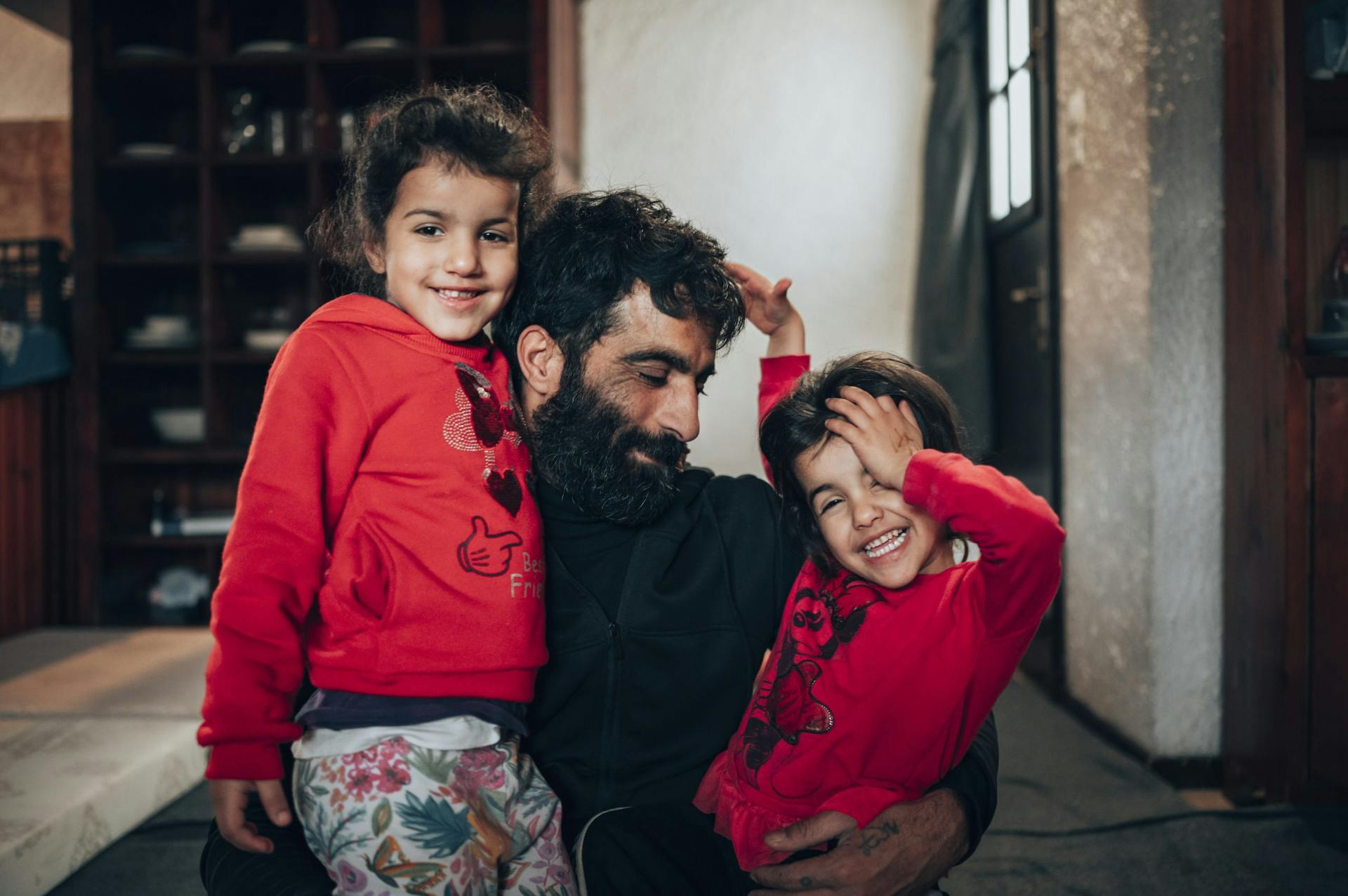 Familie Almousa is gevlucht uit Syrië, de vader van het gezin staat op de foto met twee van zijn dochters in Griekenland waar ze naartoe zijn gevlucht