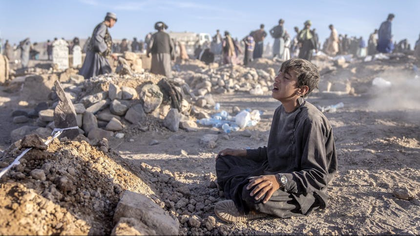 An Afghan boy mourns next to the grave of his little brother who died due to an earthquake, in Zenda Jan district in Herat province, western of Afghanistan, Monday, Oct. 9, 2023. Saturday's deadly earthquake killed and injured thousands when it leveled an untold number of homes in Herat province. (AP Photo/Ebrahim Noroozi)