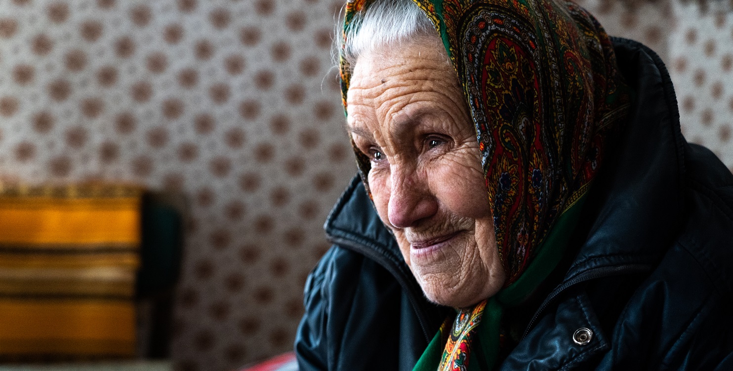 Foto van een oudere vrouw genaamd Vera (85) uit Oekraine. Ze woont alleen in Zolochiv. Ze verloor recent haar twee zonen die zich aansloten bij het Oekraïnse leger. Ze stierven aan het front.