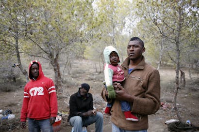 Een man uit Kameroen houdt zijn baby vast terwijl ze schuilen in een vluchtelingenkamp dichtbij Marokko en de Spaanse grens.
