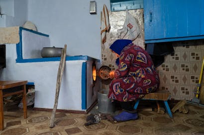 oudere vrouw maakt kachel aan in kherson, oekraine