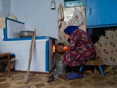 oudere vrouw maakt kachel aan in kherson, oekraine