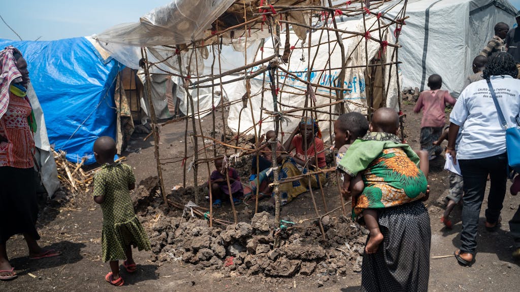 Mensen zoeken de schaduw op in een vluchtelingenkamp bij Goma