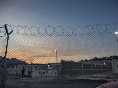vluchtelingenkamp op samos achter prikkeldraad tijdens zonsondergang