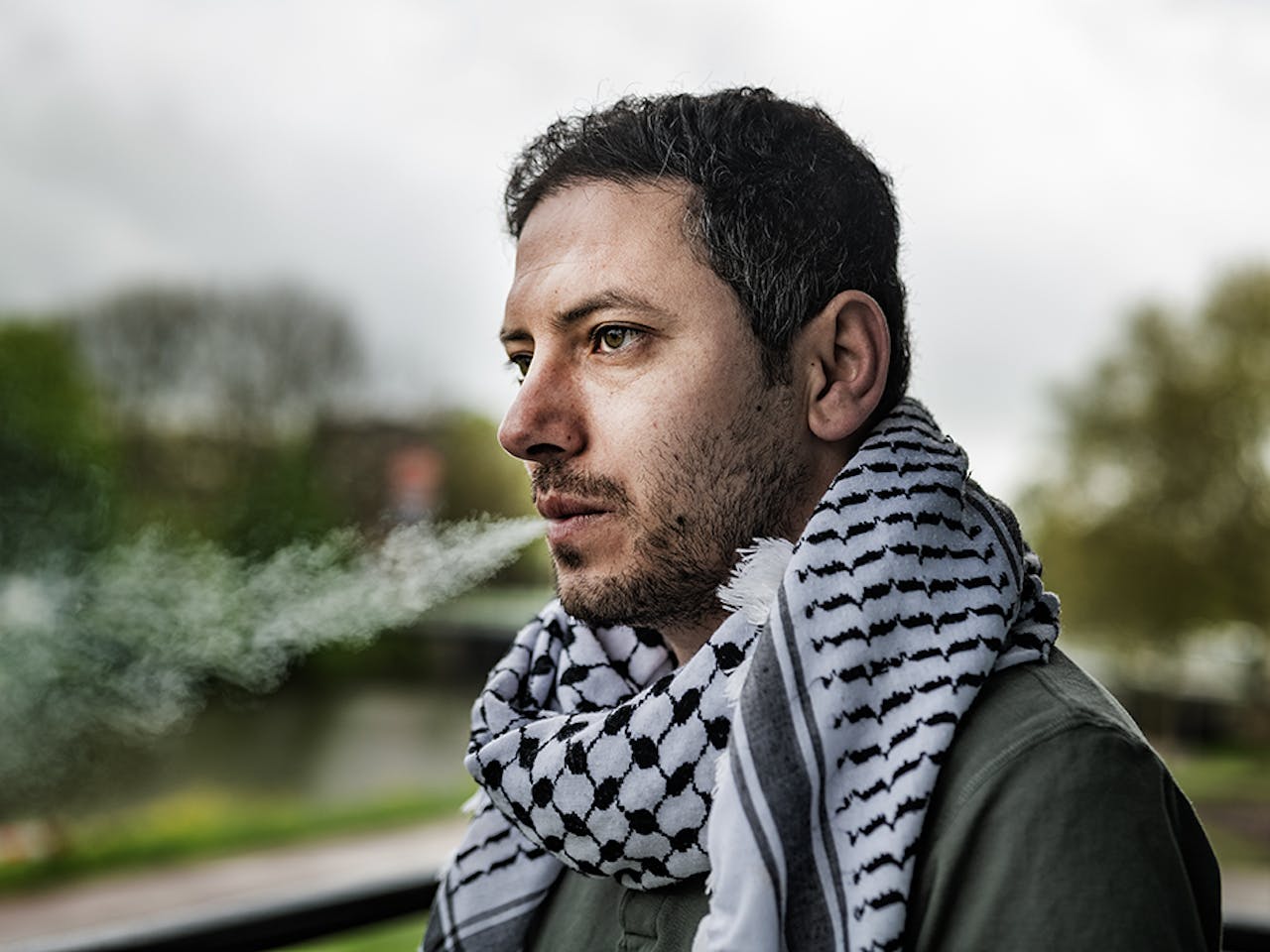 foto van een Palestijnse man genaamd Wasim die een sigaret rookt op een balkon