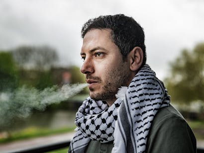 foto van een Palestijnse man genaamd Wasim die een sigaret rookt op een balkon