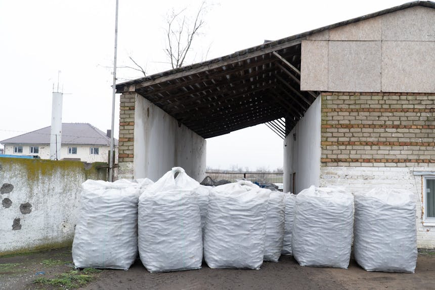 brandstofbrikketten in grote witte zakken staan voor een pand in Oekraine