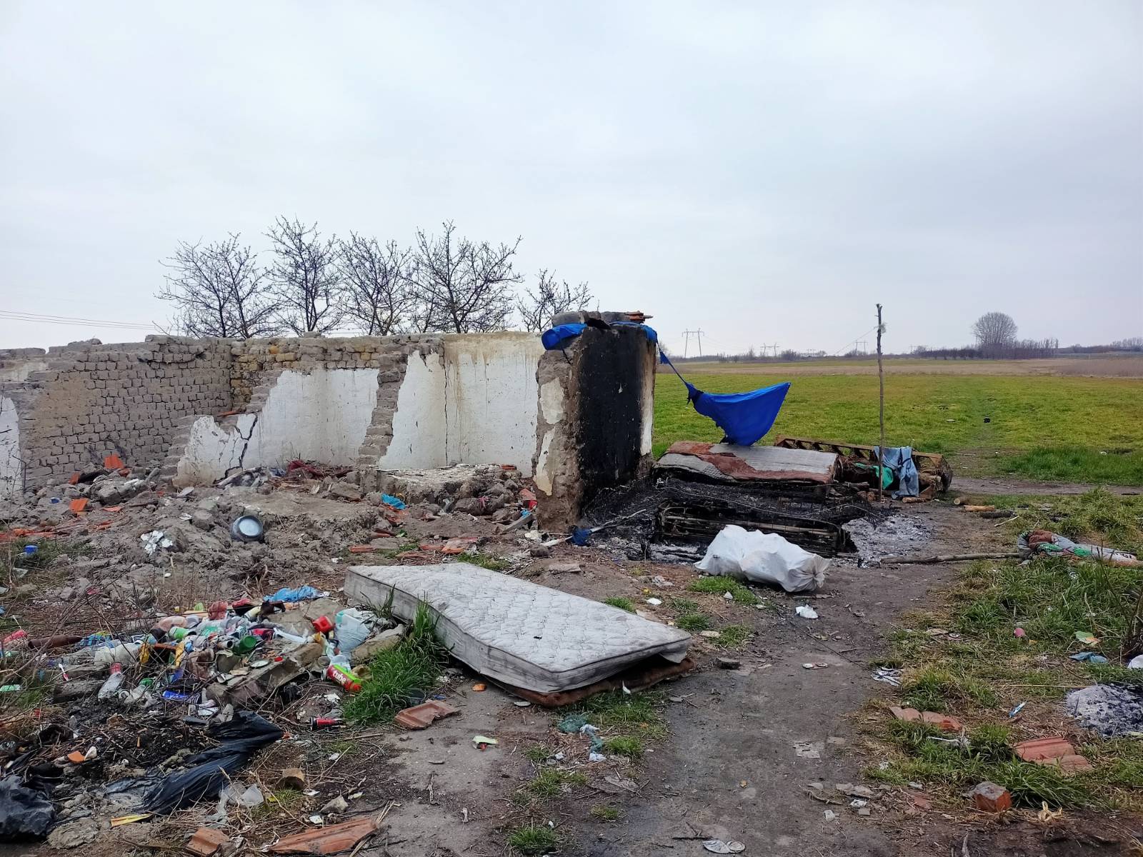 vervallen pand waar vluchtelingen schuilen. op de grond ligt veel afval.