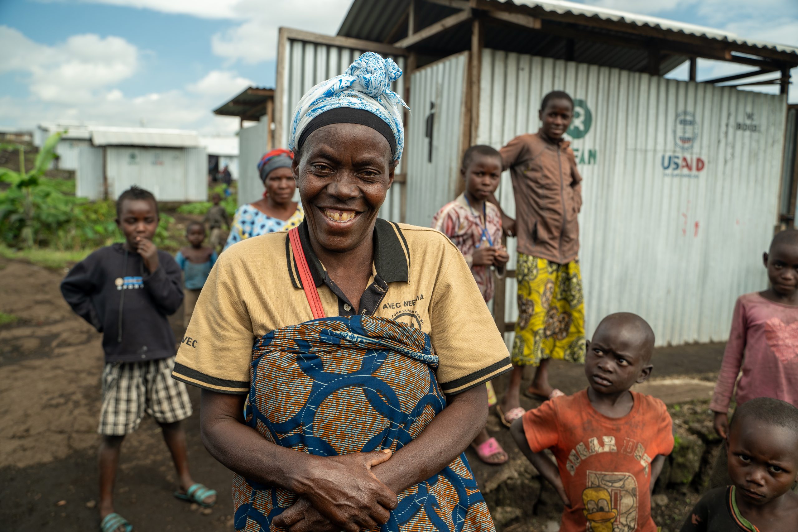 Een vrouw kijkt lachend in de camera. DR Congo.