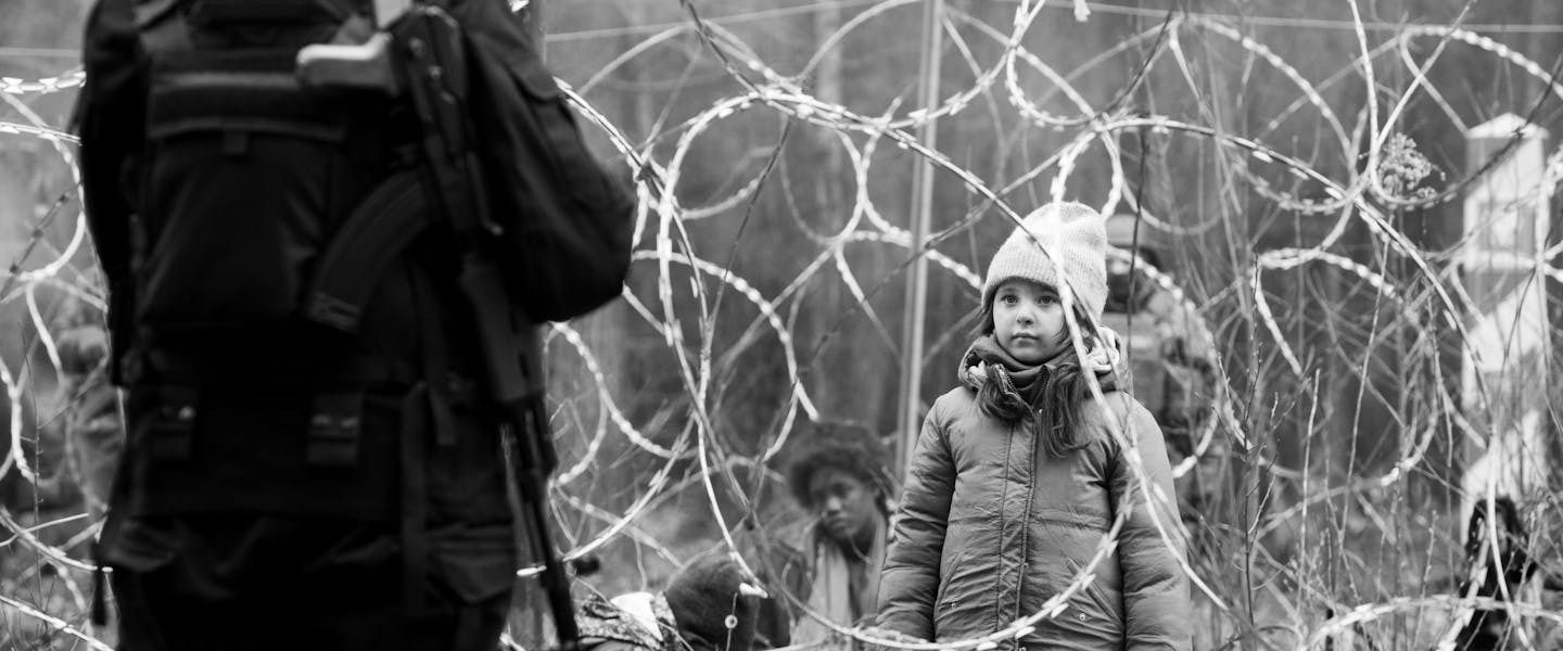 jong meisje voor prikkeldraad, beeld uit de film Green Border