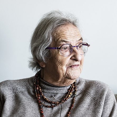 Portret van Mieke van Creveld-Zeehandelaar (87 jaar). Ze draagt een bruine kralenkretting, bril en grijze trui.
