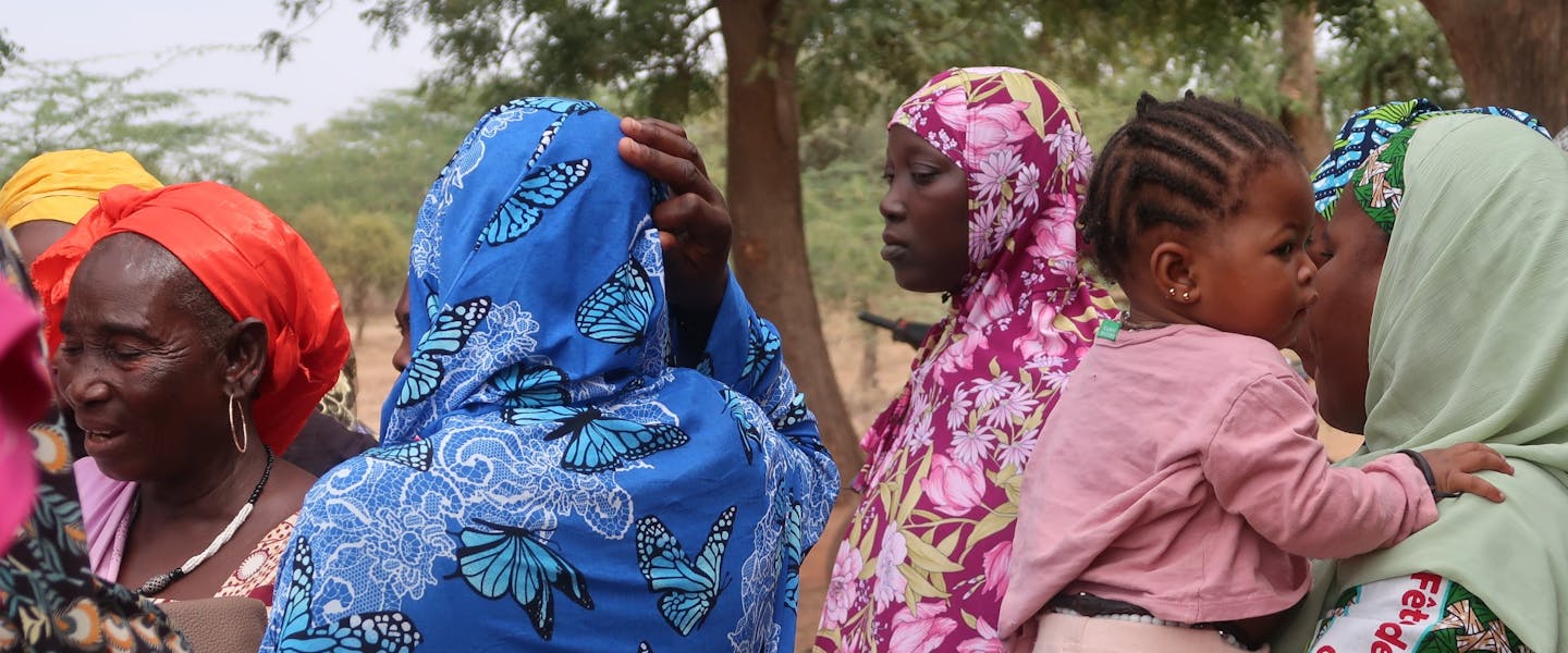 Een groep vrouwen in Mali. Een van de vrouwen houdt een kind in haar armen.
