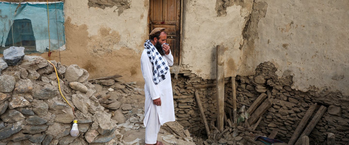 een man staat op brokstukken na de zware aardbeving in Afghanistan