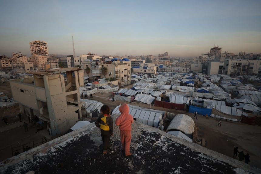 Palestijnse kinderen kijken uit over een vluchtelingenkamp in Gaza