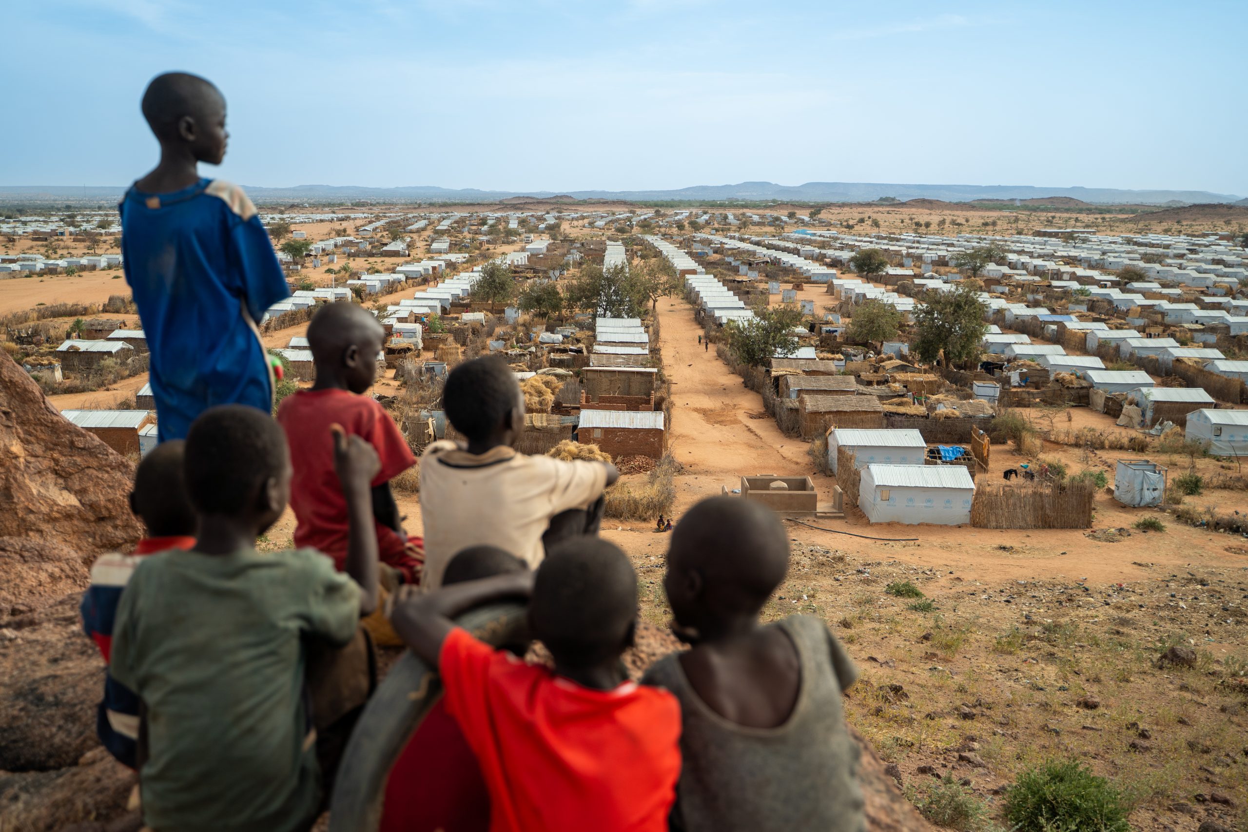 Een groep kinderen kijkt uit over het Farchana vluchtelingenkamp in Tsjaad