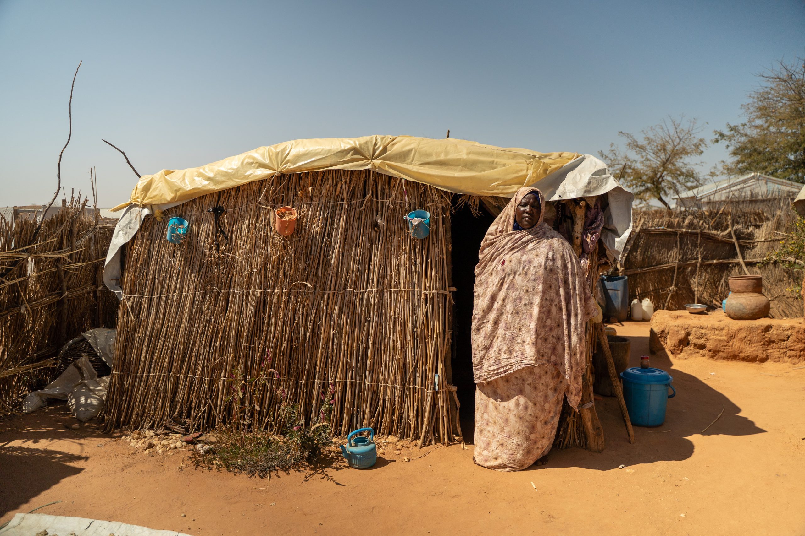Zahra staat voor haar onderkomen in het vluchtelingenkamp in Tsjaad