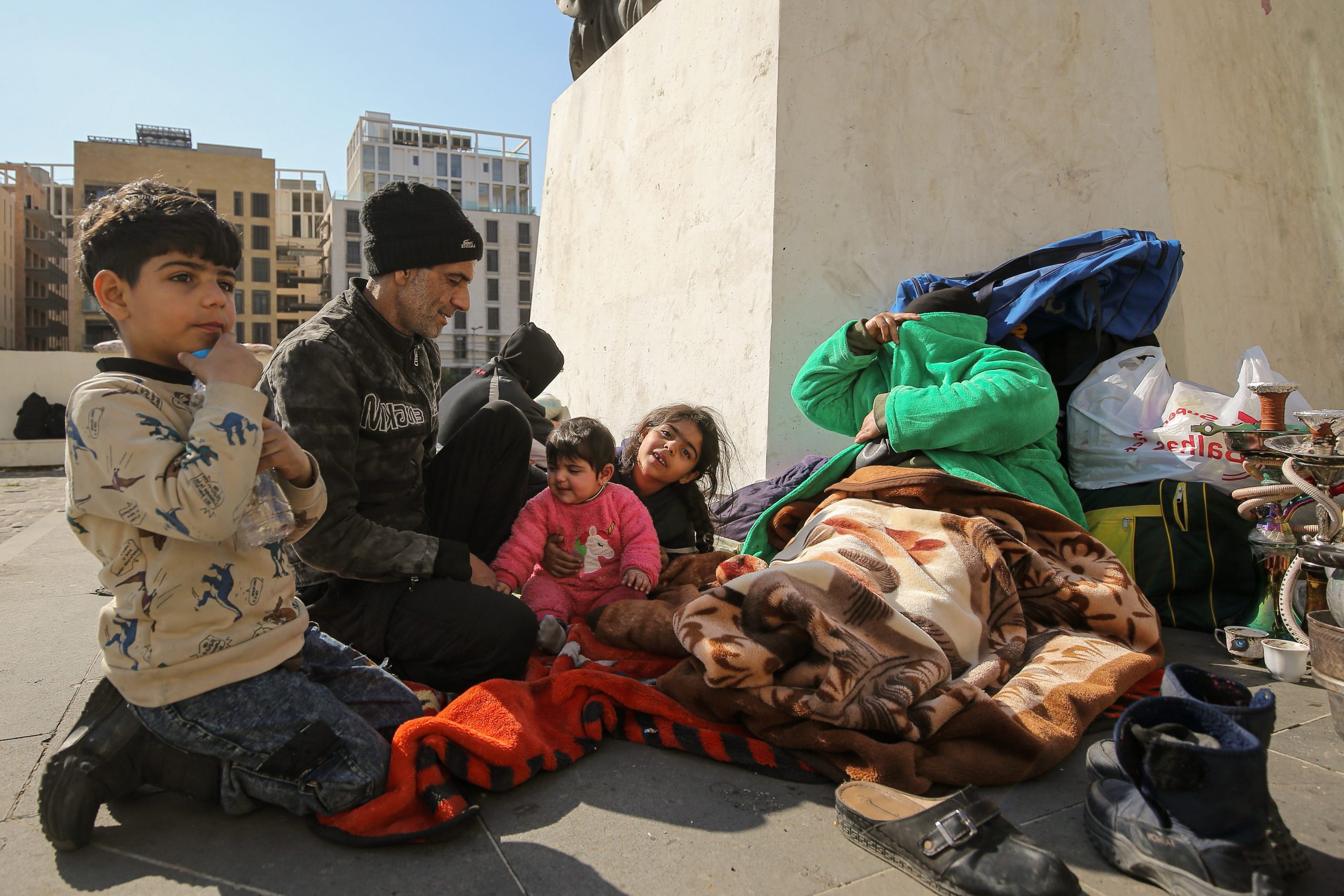 Een gevluchte familie slaapt op straat in Beiroet nadat ze hun huis hebben moeten verlaten