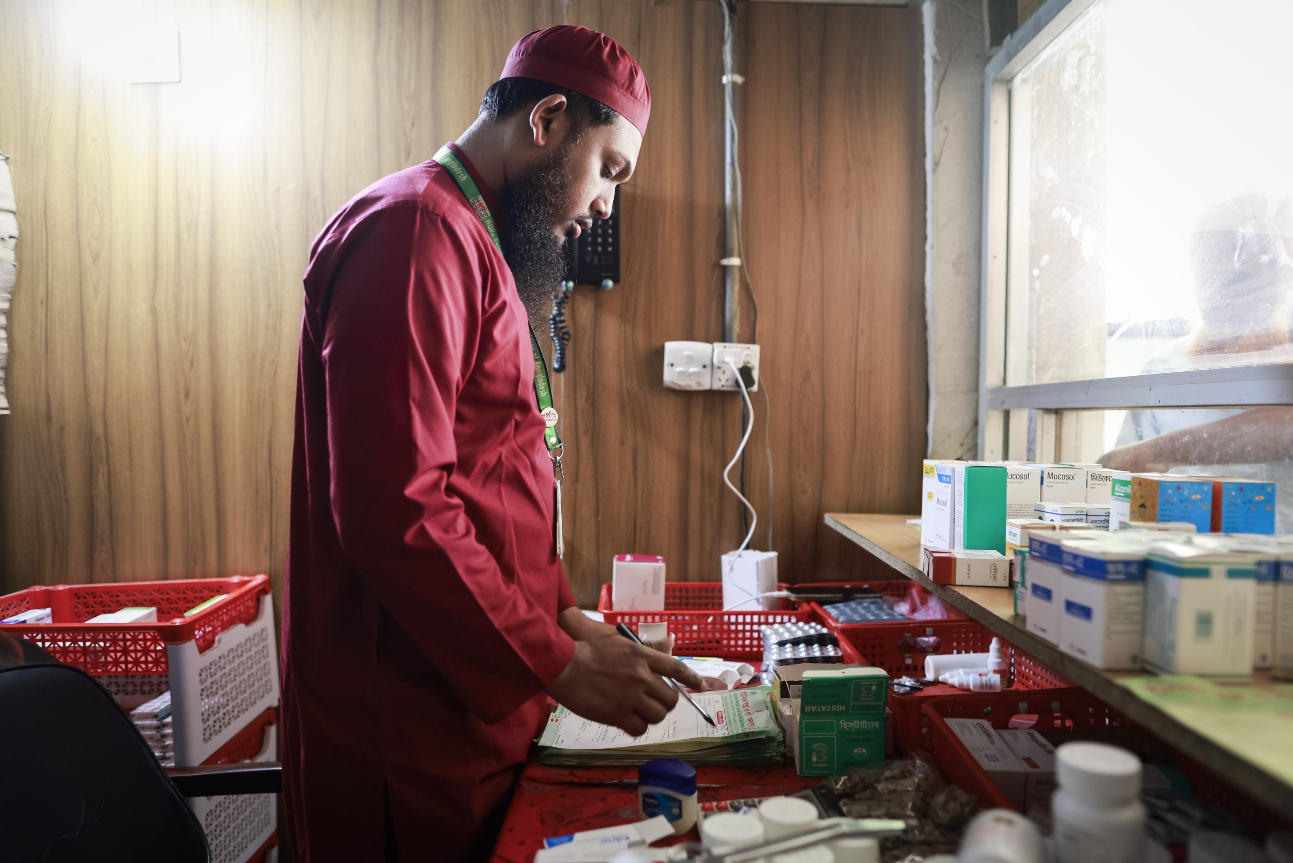 Een medewerker van het HOPE ziekenhuis bij de medicijnenvoorraad in Cox's Bazar, Bangladesh