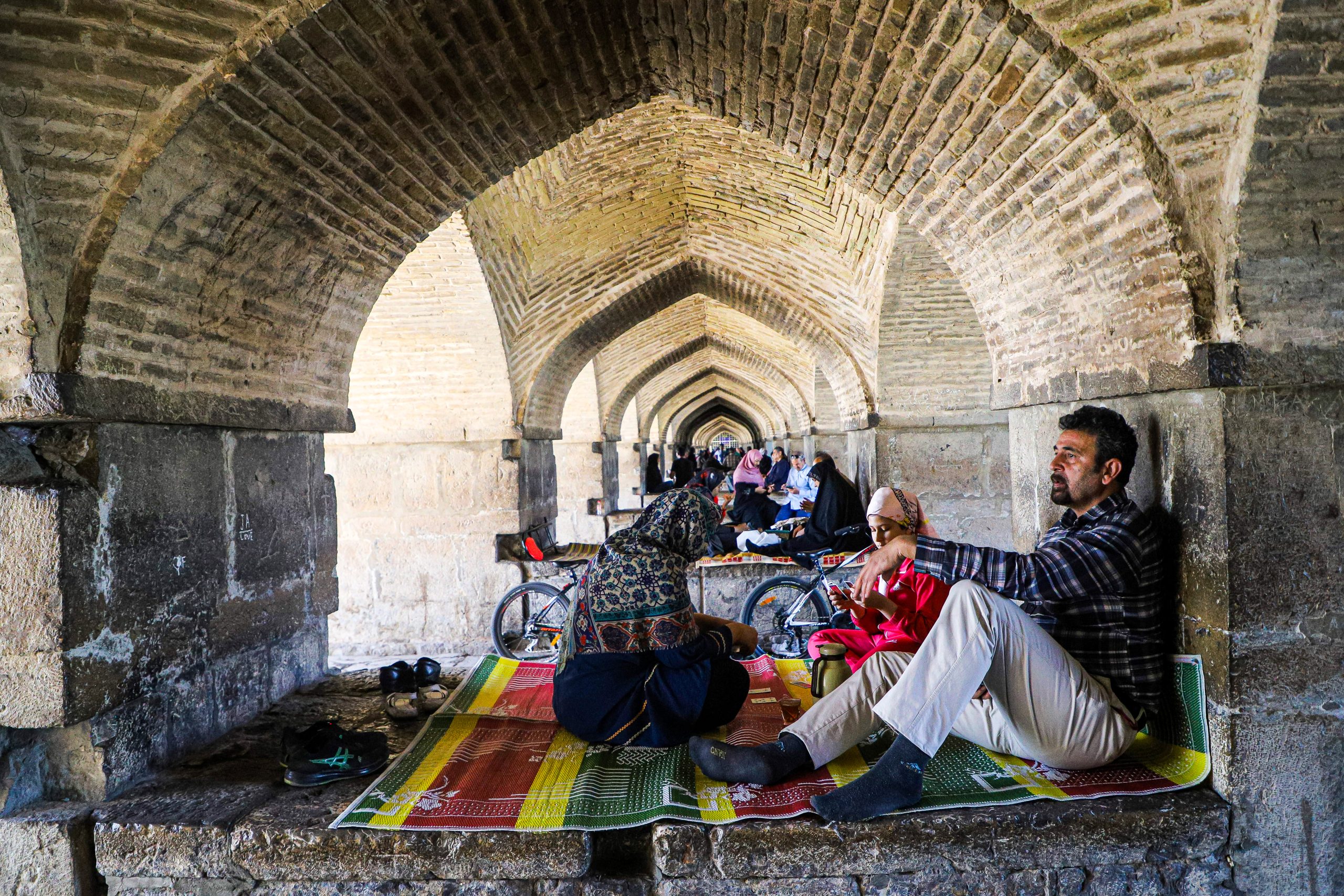 Een Iraanse man zit op een kleed in Teheran, Iran