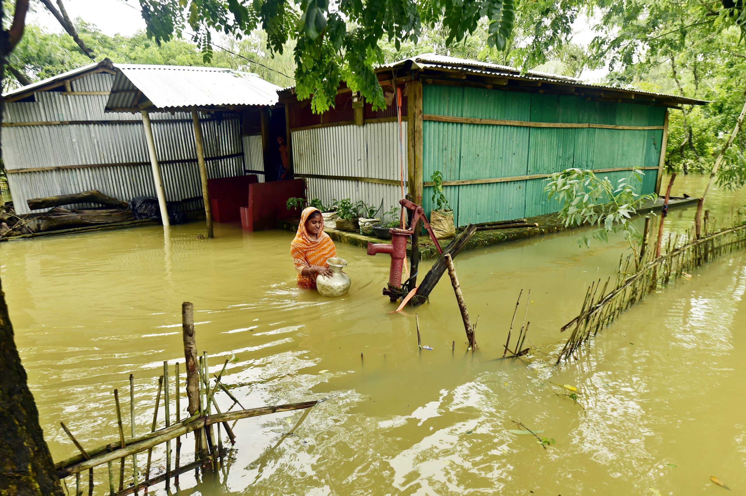 een vrouw haalt schoon drinkwater in overstroomd Cox Bazar, vluchtelingenkamp in Bangladesh